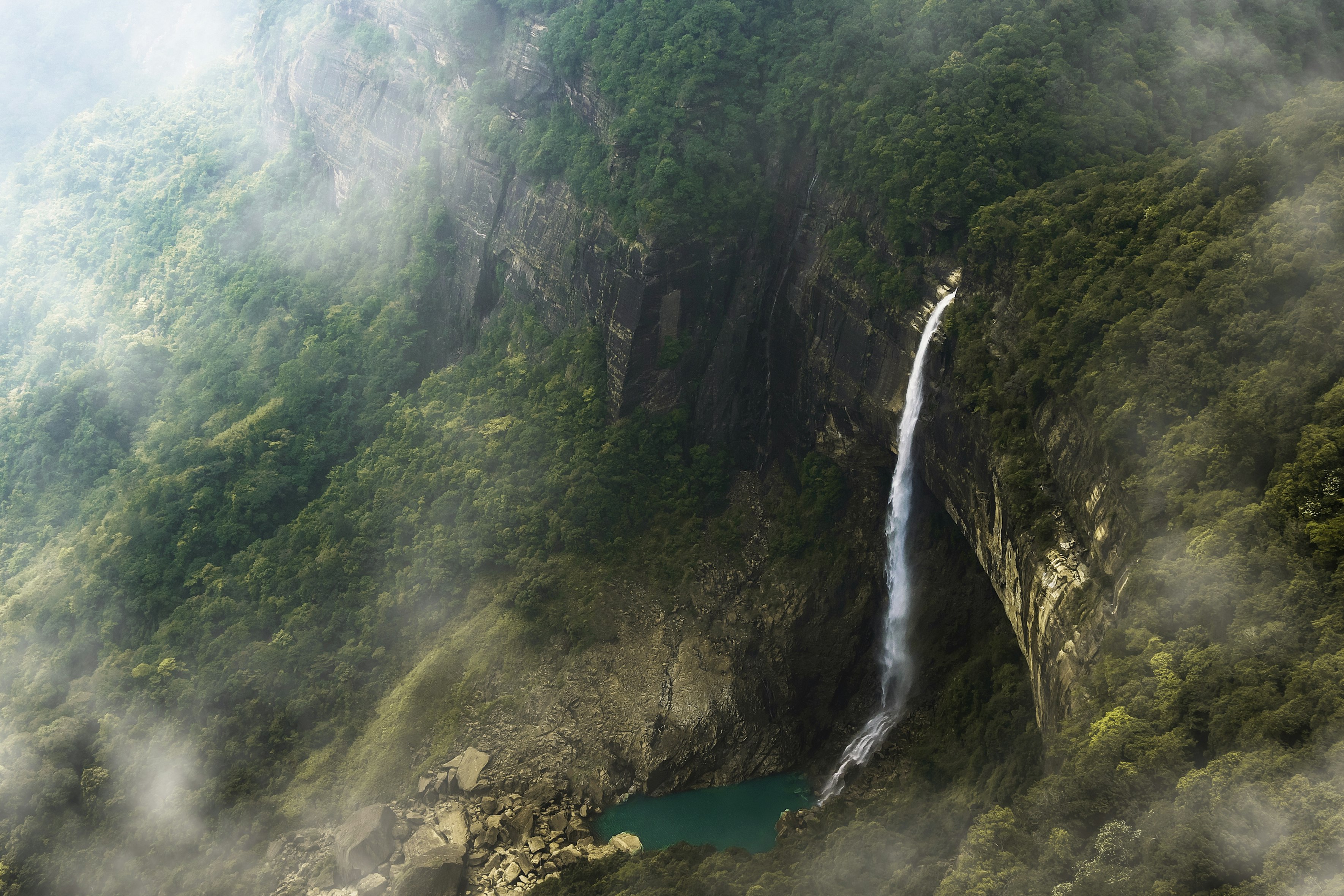 Nohkalikai Falls in full spate, root bridges covered in moss